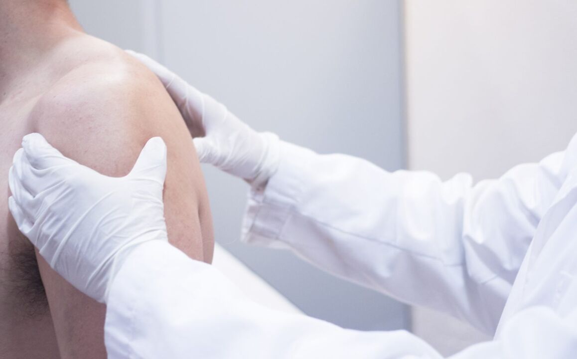 o médico examina o ombro com artrose